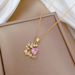 Elegant gold necklace with pink heart zircon and leaf pendant on a silk display