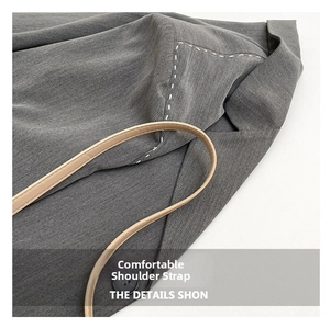 Detail of grey fabric texture with white contrast stitching and slim leather strap