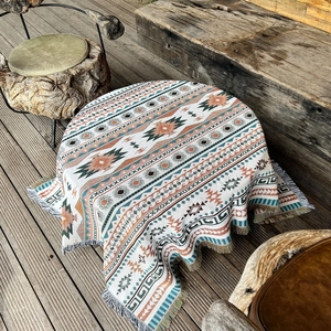 Detail of bohemian geometric woven blanket with tassels on a wooden terrace
