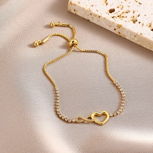 Detail of gold heart infinity bracelet with sparkling cubic zirconia on satin background