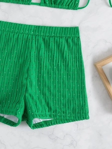 Detail of green bikini bottom featuring vertical wavy texture and hollow-out knit fabric