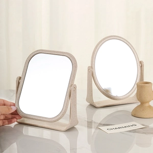 Adjustable rectangular and round wheat straw tabletop makeup mirrors on marble surface