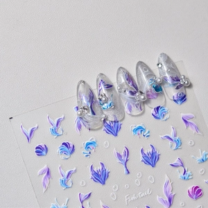 Detail of fish tail nail stickers with shells and pearls on a purple beach theme