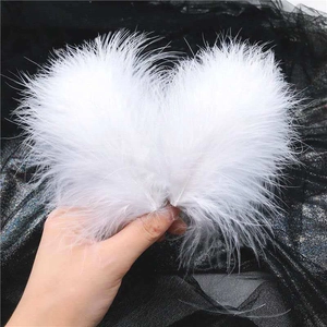 Dettaglio dell'elegante fermaglio per capelli in piume bianche con design ad ali