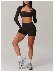 Detail of high-waisted seamless yoga shorts and cropped long sleeve top in dark coffee