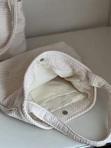 Detail view of woven shoulder bag interior with magnetic clasp and inner pocket