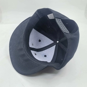 Detail view of black flat brim hip hop hat with adjustable plastic strap and metal eyelets