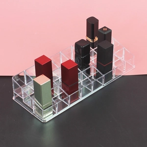 Close-up of clear acrylic lipstick organizer with multiple compartments for cosmetics