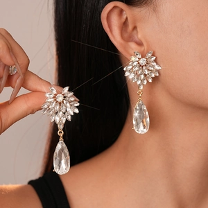 Elegant gold drop earrings with marquise crystals and large teardrop pendants on model