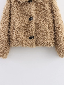 Detail view of the camel faux fur jacket showing high-quality curly texture and black button