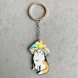 Rainbow gradient mushroom cat cartoon keychain in wood-style finish on a neutral base