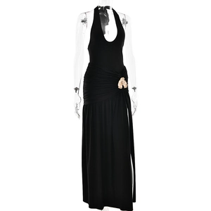 Detail of black halter maxi dress featuring waist pleats and a gold shell buckle ornament
