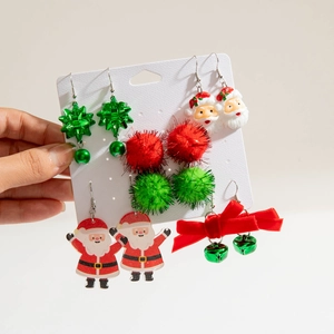 Detailed view of five pairs of Christmas earrings including Santas, bows and bells on card