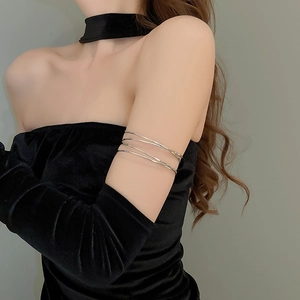 Close-up of a silver multi-layer winding metal arm cuff on a model wearing black velvet