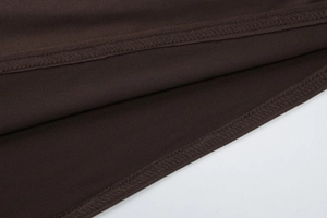 Macro shot of dark brown dress fabric showing precise overlock stitching and fine textures
