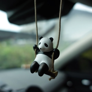 Close-up of a cute panda swinging ornament with matte texture for car rearview mirror
