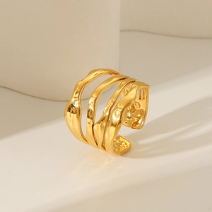 Macro detail of gold plated irregular wavy lines stack ring on a minimalist background