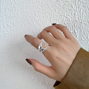 Macro detail of irregular liquid metal silver ring on finger with adjustable open band