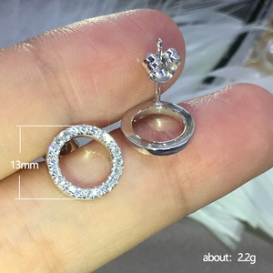 Minimalist silver geometric round hoop earrings with sparkling cubic zirconia on fingertip
