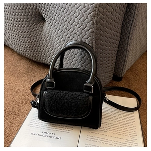 Detail of black stylish handbag with plush pocket texture on a decorative vintage book