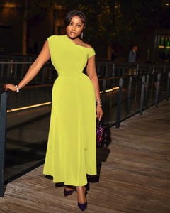 Detail of neon yellow off-shoulder maxi dress with ruched waist in outdoor setting