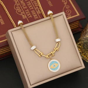 Macro view of gold evil eye enamel pendant with pavé cubic zirconia and multi-strand chain