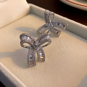Close-up of elegant bow-knot earrings with sparkling zircon inlay in a premium jewelry box