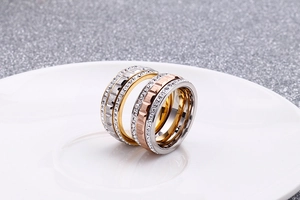 Macro shot of rose gold, gold and silver stacked rings with cubic zirconia crystal inlay