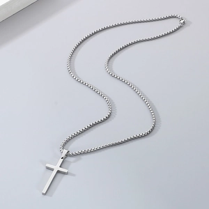 Polished stainless steel cross pendant necklace with a sleek box chain on grey background