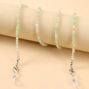 Colorful crystal beaded eyewear chain with green and orange beads on a neutral display