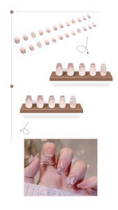 Detail of pink gradient press-on nails with 3D butterfly, pearls and glitter finish
