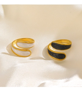 Detailed macro view of 18K gold plated bypass rings with black and white enamel marble texture