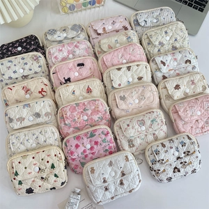 Close-up of quilted fabric organizers with cute floral patterns and button closures