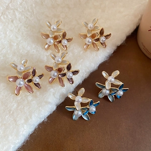 Close-up of 18K gold plated flower earrings with pearls on white fleece background
