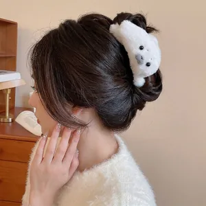 Cute white plush seal hair claw clip for women styled in a cozy winter hair bun