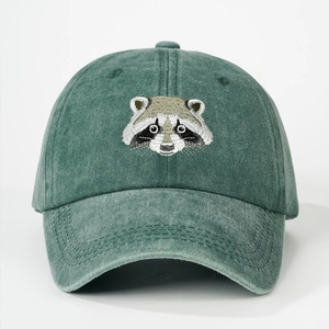 Close-up of raccoon embroidery on green washed cotton baseball cap with fine stitching