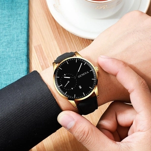 Close-up of Geneva men's quartz watch with gold case and black leather strap on wrist