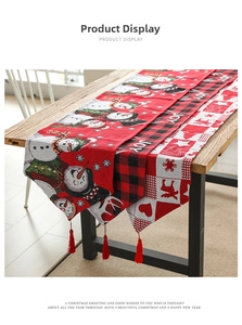 Close-up of Christmas table runners with snowman, JOY motifs and red tassel details