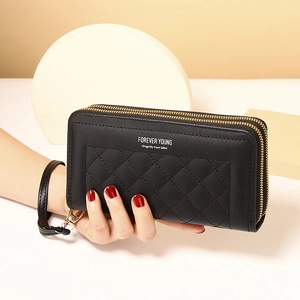 Detail of black quilted leather long wallet with double zippers and wrist strap accessory
