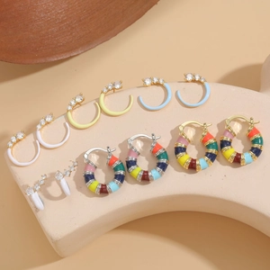 Close-up of colorful enamel and cubic zirconia C-shaped earrings on light display stand