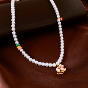 Détail d'un collier de perles avec billes colorées et pendentif cheval sur satin