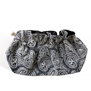 Elegant black drawstring clutch bag with white paisley embroidery and a pearl detail