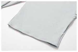 Detailed close-up of double-stitched hem on light blue-grey quick-dry yoga top fabric