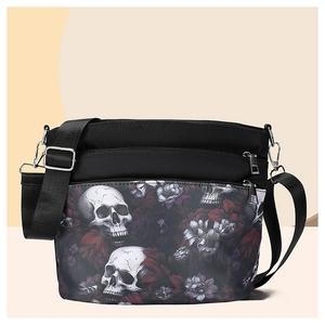Detail of dual zipper compartments and skull floral print on a black gothic crossbody bag