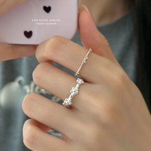 S925 sterling silver hollow bow and flower rings on a model's hand in silver finish