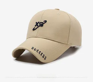 Détails des broderies XS et Success sur une casquette de baseball en coton beige