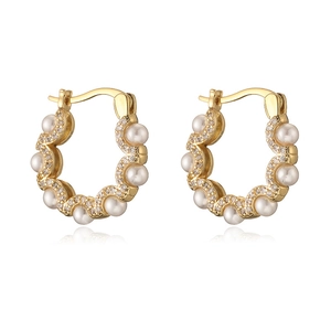 Golden wave hoop earrings with inlaid pearls and sparkling crystals on white background