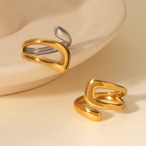Detailed shot of gold and silver irregular streamlined open rings on a ceramic tray
