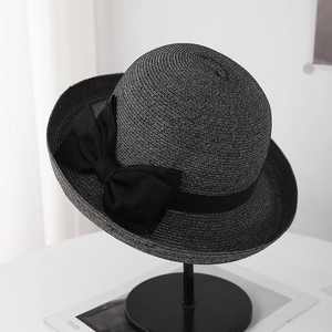 Detail van elegante zwarte strohoed met een grote decoratieve zijden strik als accent.