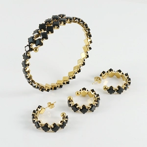 Luxurious gold jewelry set with black square gemstones including bracelet and earrings
